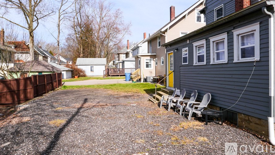 A gravel driveway leads to a house with a yellow door.