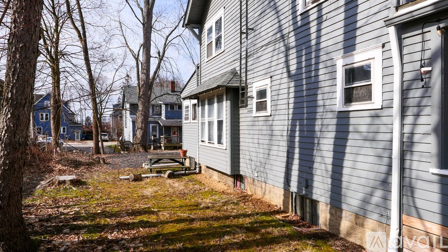 A grey house with a white window and a door.