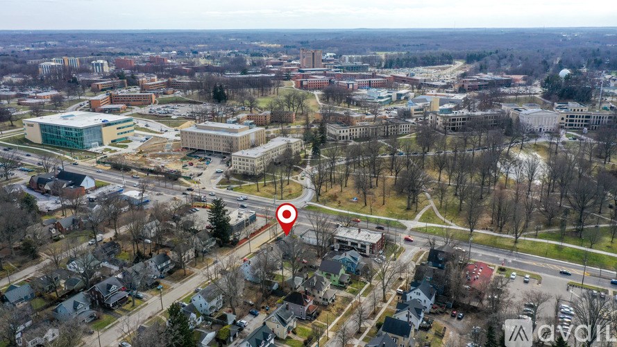 An aerial view of a city with a red pin on a road.