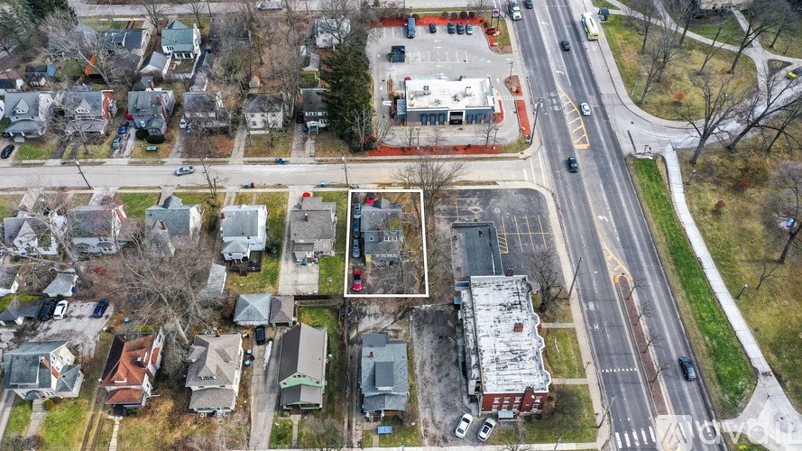 A street view of a residential area with houses and cars.