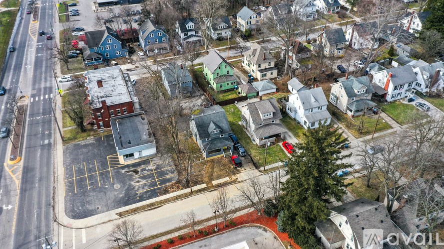 A bird's eye view of a residential area with houses and a parking lot.