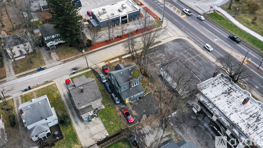 A parking lot with cars and a building with a red roof.