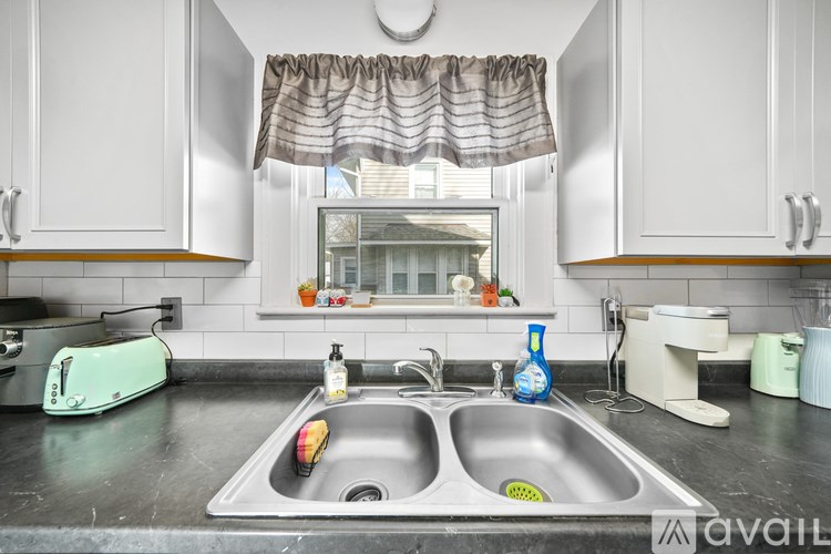 A kitchen with a sink and a toaster on the counter.