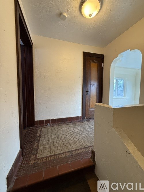 A hallway with a tiled floor and a door.