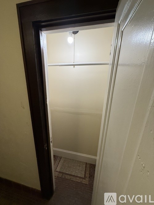 A small dark brown door with a light on inside.