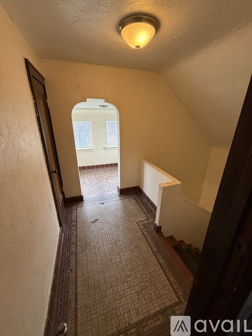 A hallway with a tiled floor and a skylight.