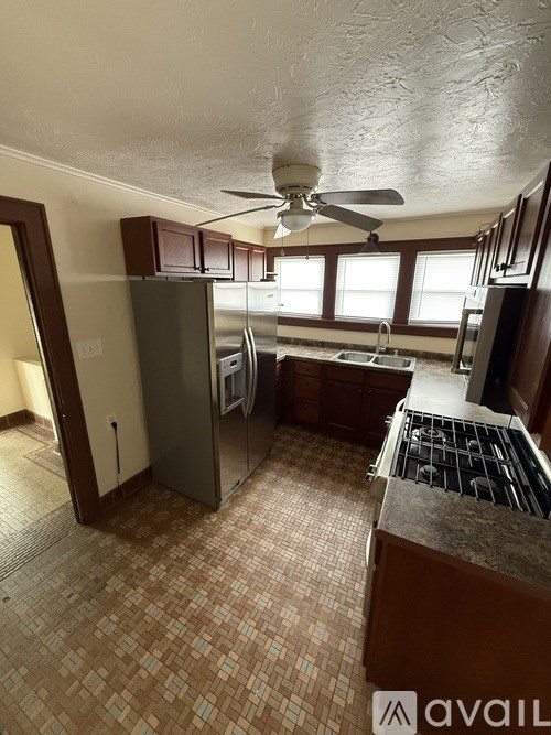 A kitchen with a tile floor and a refrigerator.