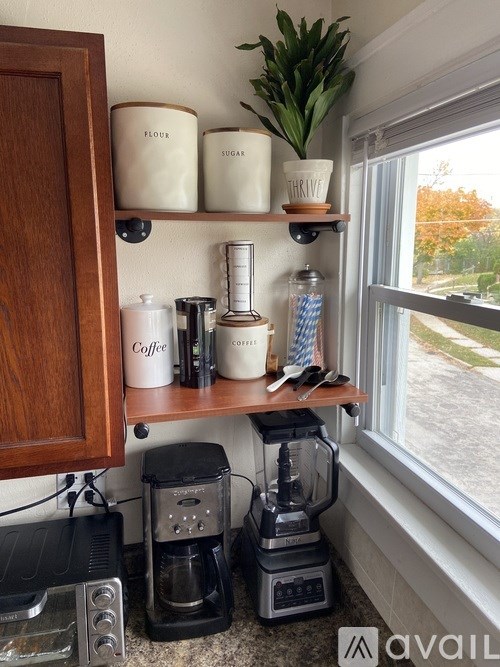 A kitchen with a coffee maker and a blender on the counter.
