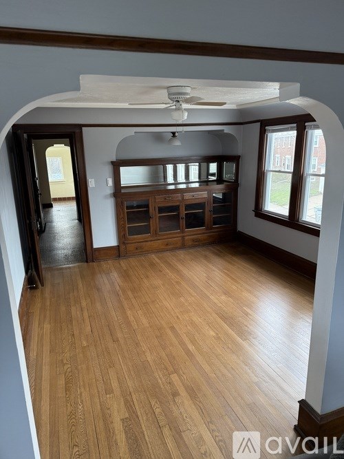 A room with wooden floors and a ceiling fan.