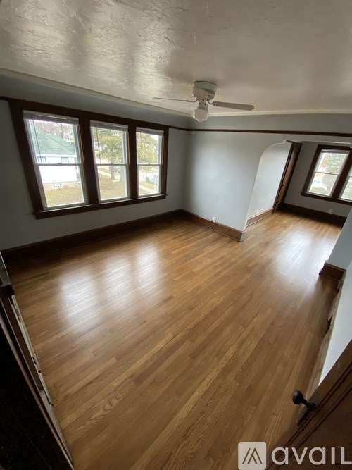 A room with wooden flooring and a ceiling fan.