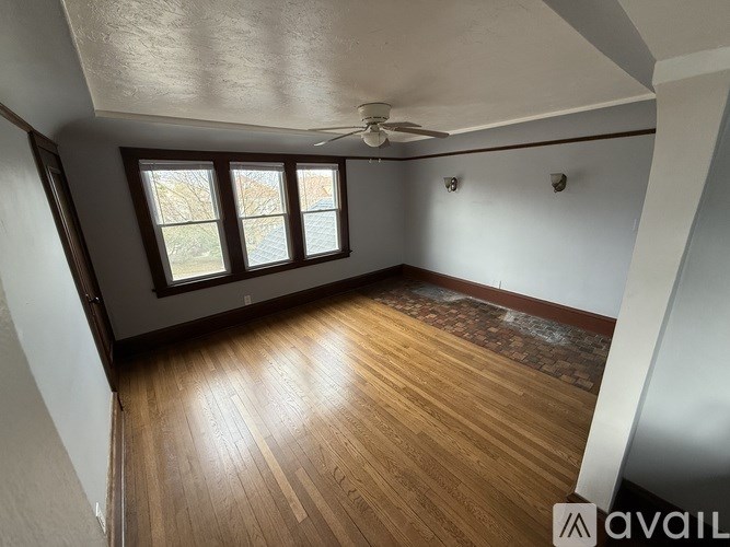 A room with wooden flooring and a ceiling fan.