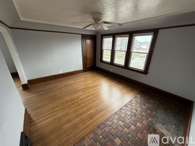 A room with wooden flooring and a ceiling fan.