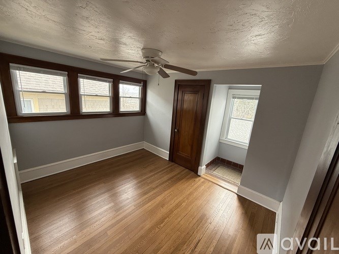 A room with wooden floors and a ceiling fan.