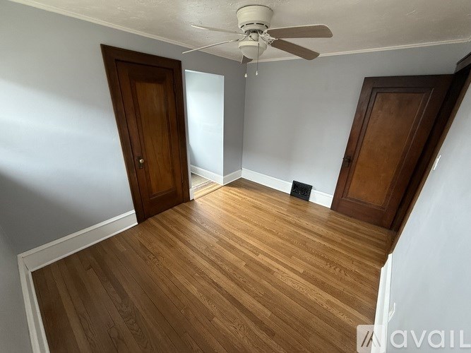 A room with wooden floors and two doors.