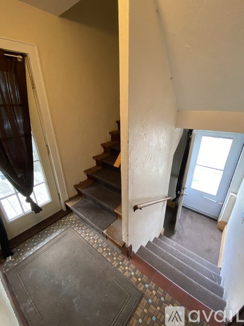 A staircase with a tiled floor and a metal handrail.