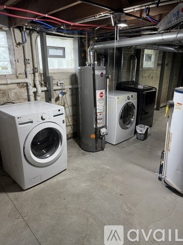A room with a washing machine and a dryer.
