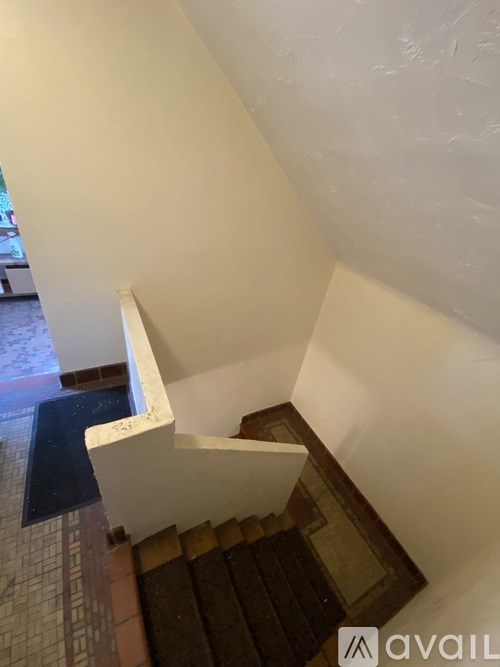 A staircase with a black mat on the floor.