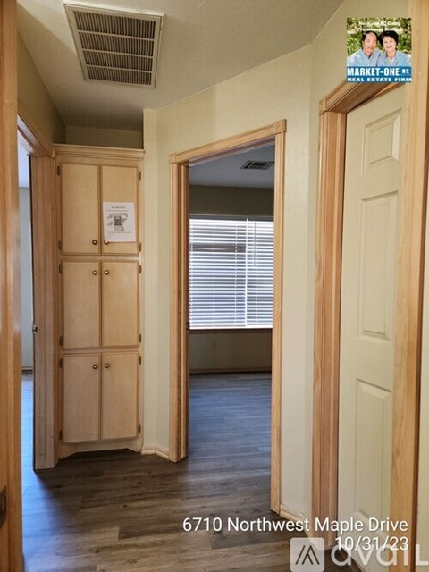 A room with a wooden floor and a wooden wardrobe with a sign on it.