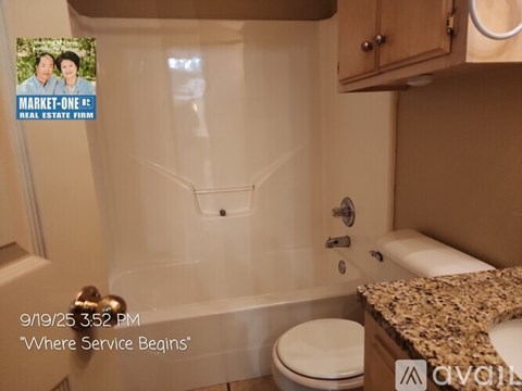 A bathroom with a poster on the wall.