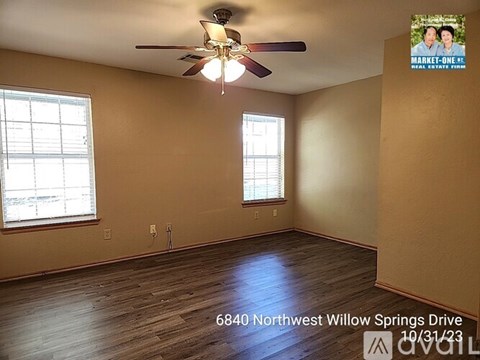 A room with a ceiling fan and two windows at 6840 Northwest Willow Springs Drive.