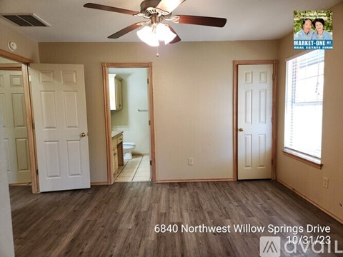 A room with a ceiling fan and a mirror on the wall.