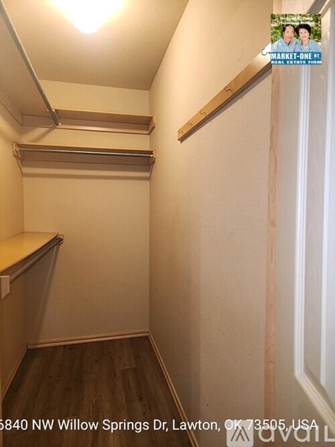 A small room with a white door and a wooden floor.