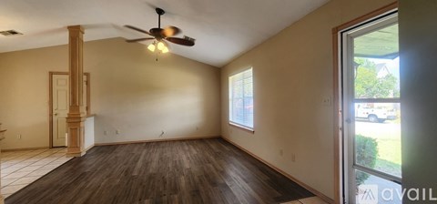 A kitchen with a refrigerator, cabinets, and a ceiling fan.