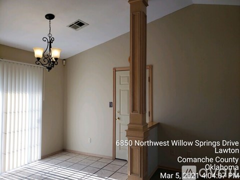 A room with a door and a chandelier in it.