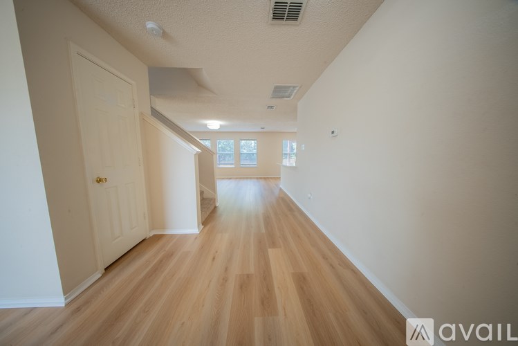 A long hallway with wooden floors and white walls.