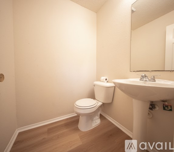 A white toilet sits next to a sink in a small bathroom.
