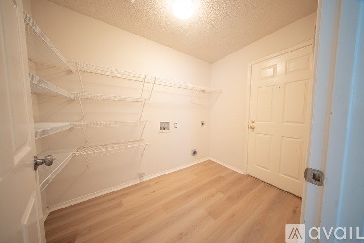 Empty room with white walls and wooden floor.