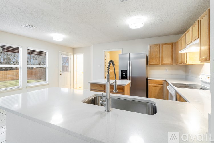 A kitchen with a white counter top and a refrigerator.