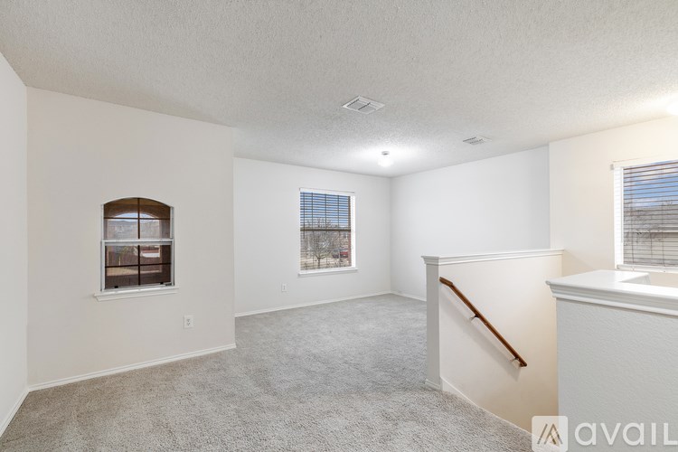 A spacious room with a window and a carpeted floor.