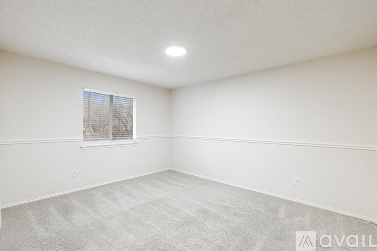 A room with a window and carpeted floor.