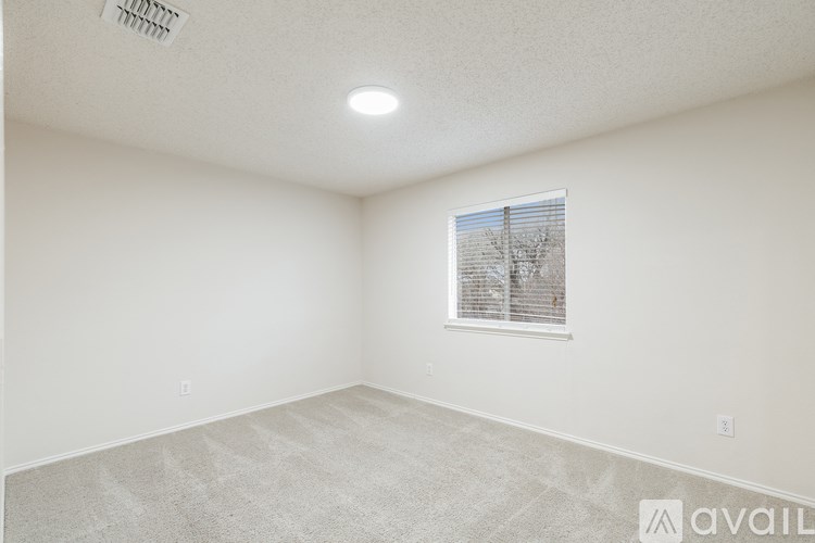 A room with a window and a carpeted floor.