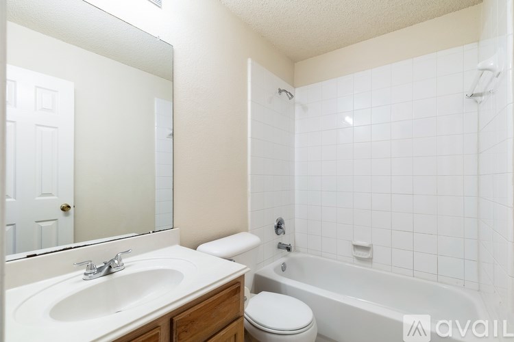 A bathroom with a white toilet, sink, and bathtub.