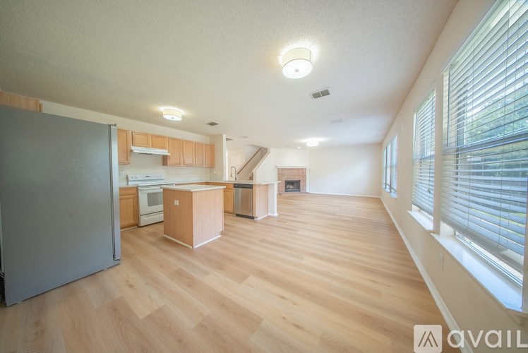 A kitchen with wooden floors and a refrigerator.