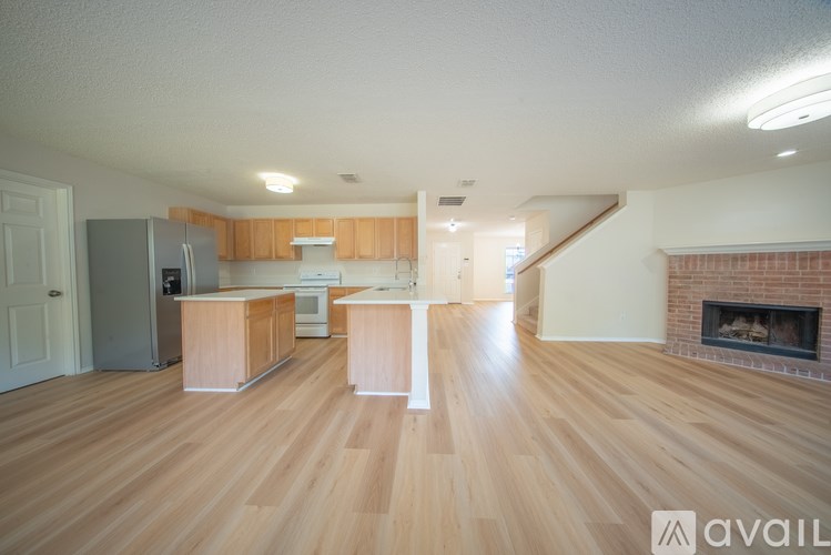 A spacious living room with wooden floors and a fireplace.