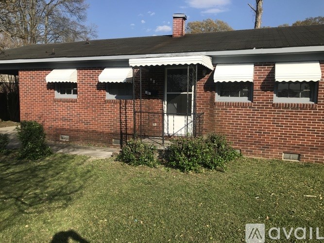 A red brick house with a white door and windows.