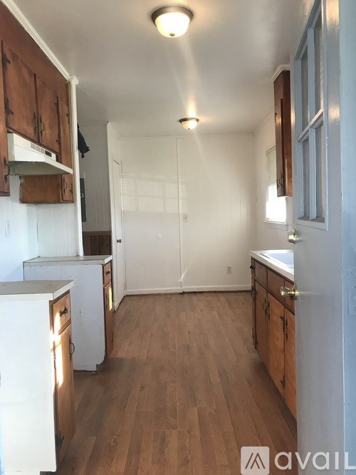 A kitchen with wooden floors and white appliances.