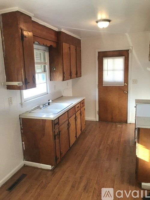 A kitchen with wooden cabinets and a white sink.