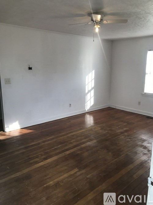 A room with wooden floors and a ceiling fan.