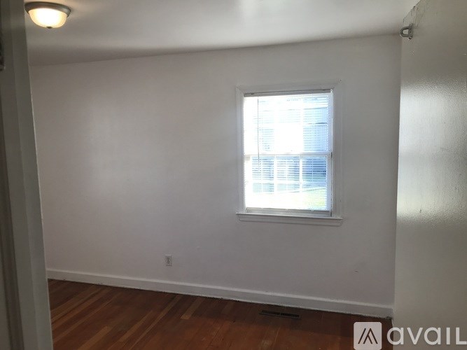 A room with a window and wooden floors.