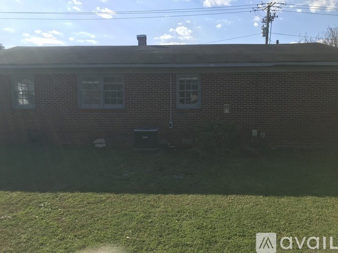 A house with a brick facade and a chimney is shown.