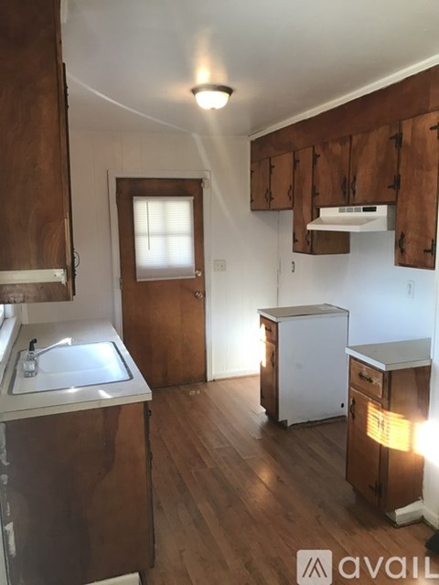 A kitchen with wooden cabinets and a white sink.