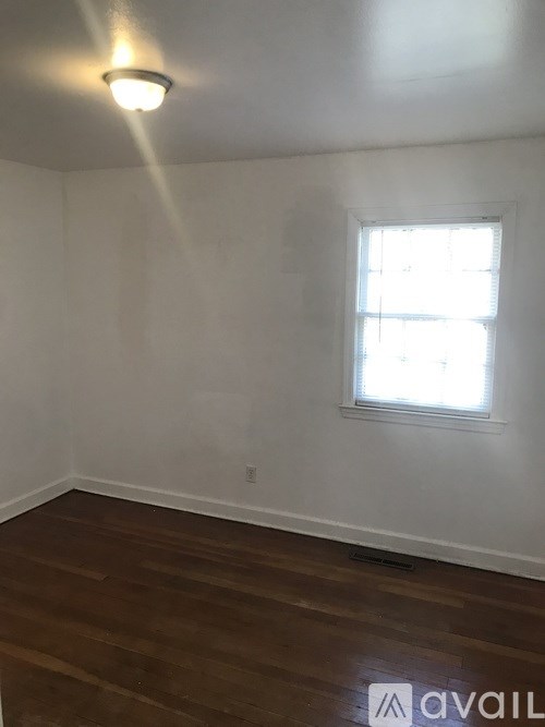 A room with a window and wooden floors.