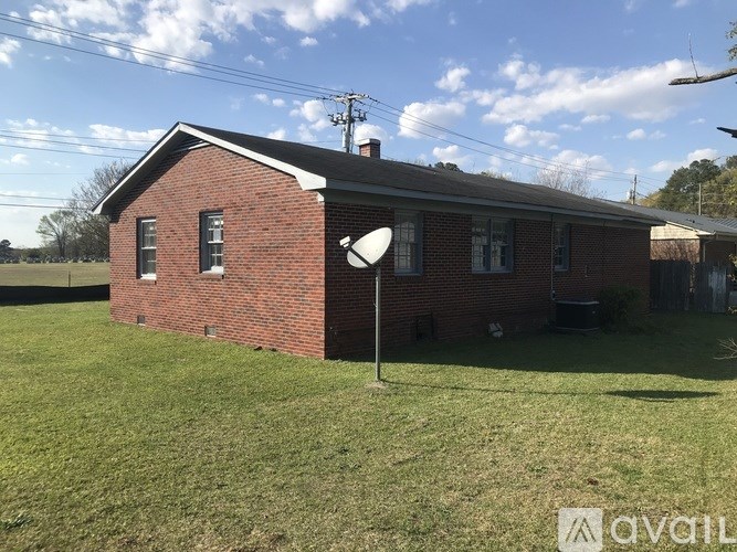 A red brick house with a white roof and a white street light in front.