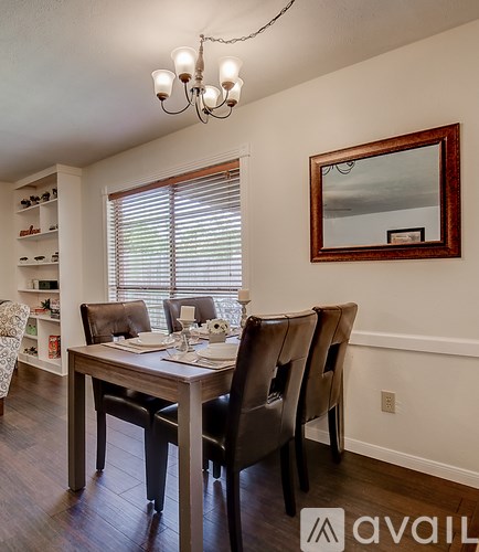 A dining room with a wooden table and chairs.