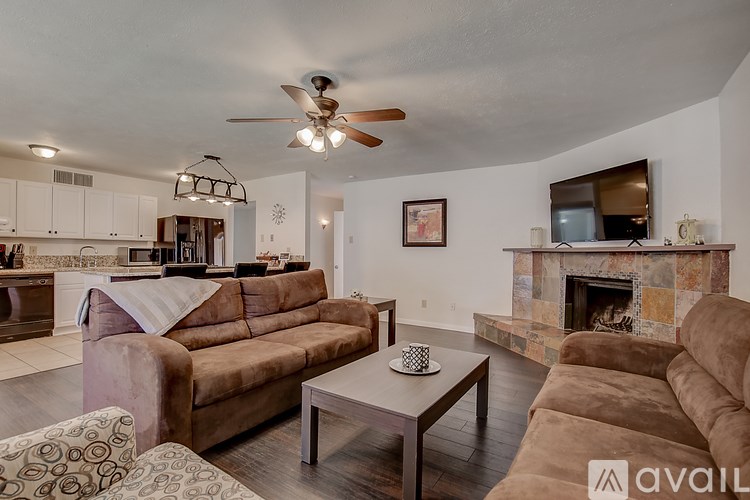 A living room with a brown couch and a fireplace.