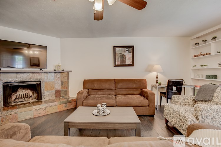 A living room with a fireplace and a brown couch.